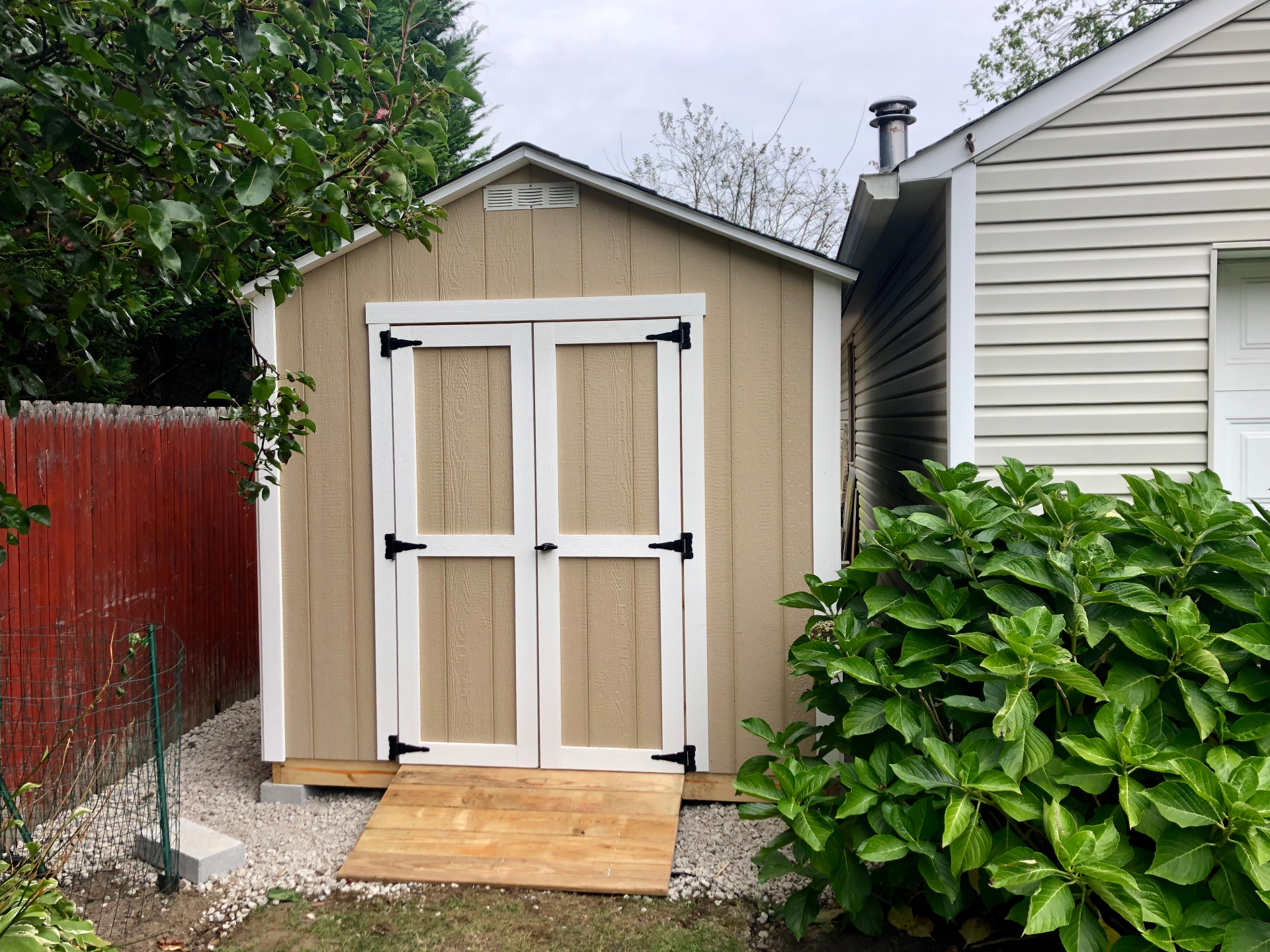 Custom tan storage shed with wood ramp built on-site in Clarksville, Indiana
