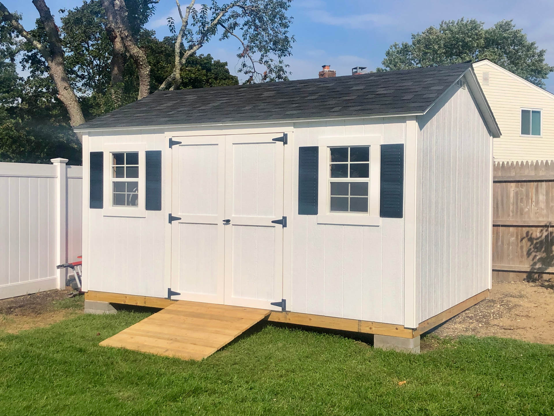 Custom white storage shed with shutters built on-site in Charlestown, Indiana
